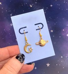 "🎁 Holiday gift wrap is now available!  Cute pair of mismatched gold-tone earrings, one with a moon moon and one with a Saturn charm. The card and white gift box are included, as shown. Perfect gift for a friend or to treat yourself! The french wire earring hooks are hypoallergenic gold-tone metal and are lead-free and nickel-free. They come with silicone stoppers. The charms are metal alloy. Every order includes a free random ts sticker as a thank you gift from me to you :) I offer gift wrapping for this item. Click on \"this order is a gift\" at checkout for details. Check out my shop for more ts jewelry, including the coordinating necklace: https://www.etsy.com/listing/1408230337/moon-saturn-necklaces-gold-chains-and?click_key=e80d99b19369e6d34dae3dd5a66f31d9d96dcb57%3A1408230337&click Gold Moon Charm Drop Earrings, Gold Symbolic Moon Charm Earrings, Gold Symbolic Earrings With Moon Charm, Symbolic Gold Earrings With Moon Charm, Gold Drop Earrings With Moon Charm, Symbolic Gold Moon Earrings, Symbolic Gold Moon-shaped Earrings, Gold Earrings With Moon Charm As Gift, Gold Moon Shaped Earrings For Gift