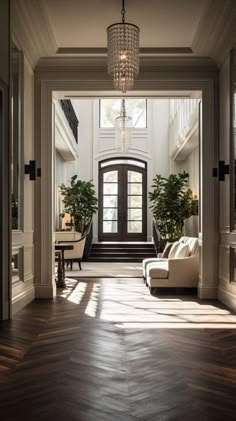 an entry way with two couches and a chandelier