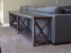 a gray couch sitting next to a wooden table