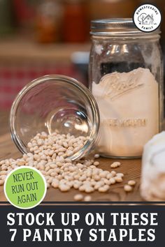 a jar filled with white beans next to a pile of other items on top of a wooden table