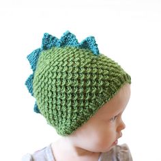 a baby wearing a green knitted hat