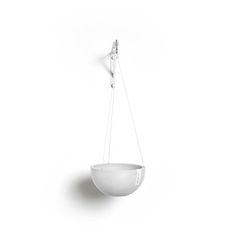 a white bowl hanging from a hook on the wall with a long cord attached to it