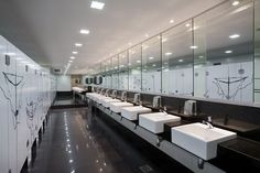 a public restroom with sinks and mirrors on the wall, all in black and white