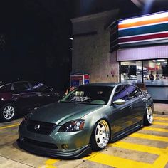 two cars parked in front of a gas station