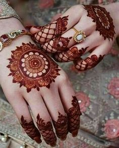 two hands with henna tattoos on them