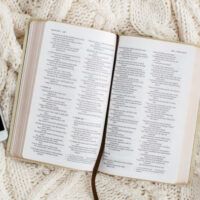 an open book and cell phone on a blanket