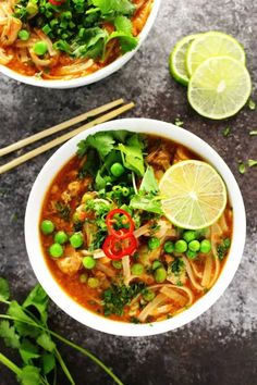 two bowls filled with soup and garnished with limes