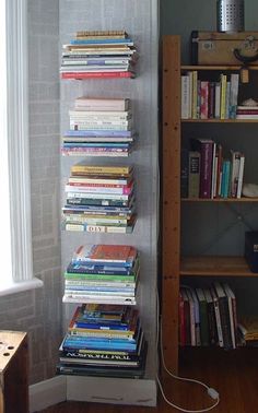 a book shelf filled with books next to a window