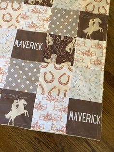 a close up of a patchwork quilt on a wooden floor with the words maverick printed on it