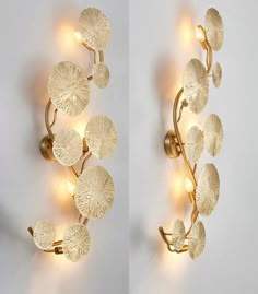 two wall sconces with lights attached to them in the shape of leaf shapes