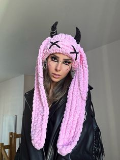 a woman with long hair wearing a pink wig and devil horns on her head is posing for the camera