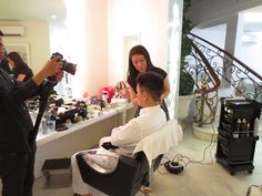 a man is getting his hair cut by a woman in a chair at the barbershop