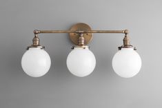 three light fixtures on a gray wall