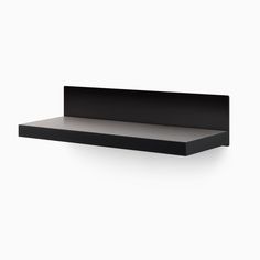 a black shelf sitting on top of a white wall