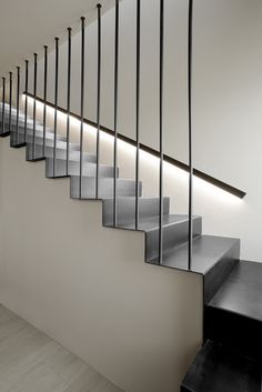 a set of stairs with black railings and white walls