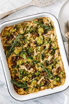 a casserole dish with broccoli, mushrooms and cheese in it on a marble surface