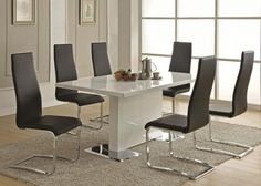 a white dining table with black chairs around it