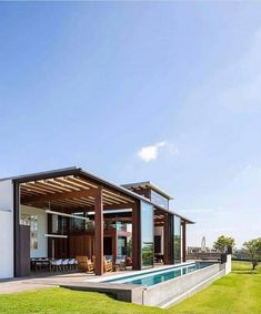 a house with a swimming pool in the middle of it's lawn and covered patio area