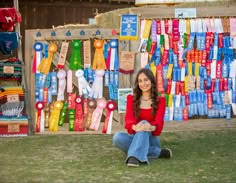 a woman sitting on the ground in front of ribbons