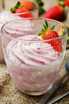 two small bowls filled with whipped cream and strawberries on top of burlly cloth