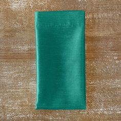 a teal colored napkin sitting on top of a wooden table