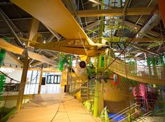 an airplane hanging from the ceiling in a building with lots of green and yellow decorations