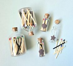 several small bottles filled with matches and wooden skewers