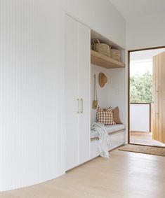 a room with white walls and wooden flooring next to a door that leads to another room