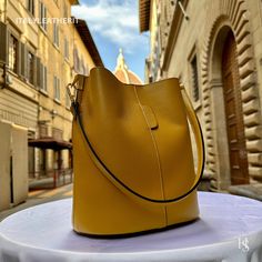 "This bag has been made of the best genuine leather by local master crafters of Florence in Italy, designed for women who only accept premium Italian quality and luxury leather bags and modern Italian fashion. . Size: Width: 27 cm / 10.75 inches Height: 19 cm / 7.50 inches Depth: 9 cm / 3.50 inches . The story of this bag : Once upon a time, in the charming city of Florence, Italy, renowned for its exquisite artistry and craftsmanship, there existed a small workshop tucked away in a cobblestone alley. This was the home of a gifted artisan named Alessio, whose passion for creating beauty out of leather was unparalleled. Alessio specialized in handcrafted leather goods, and his most prized creations were the leather clutch bags that exuded elegance and sophistication. The timeless charm of h Elegant Large Capacity Yellow Bag, Elegant Yellow Shoulder Bag For Daily Use, Leather Lined Bucket Shape Travel Shoulder Bag, Yellow Leather Shoulder Bag For Office, Yellow Soft Leather Shoulder Bag For Formal Occasions, Travel Bucket Shoulder Bag With Leather Lining, Elegant Yellow Leather Satchel, Luxury Large Capacity Yellow Shoulder Bag, Elegant Yellow Shoulder Bag For Everyday Use