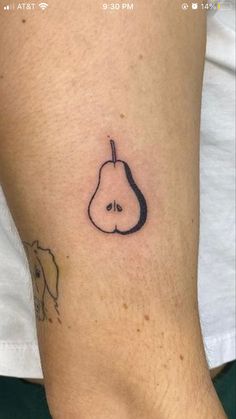 a small tattoo on the foot of a person with a pear in the shape of a heart