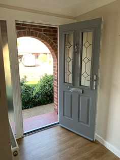 an open door leading to a patio with a brick wall and wooden floors in front of it