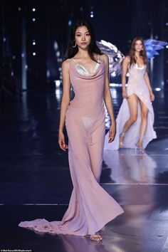 two models walk down the runway in evening gowns