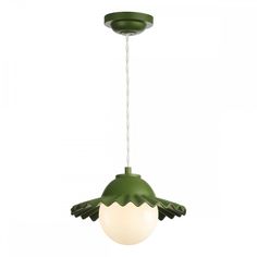 a green and white light hanging from a ceiling fixture with an egg shell on it