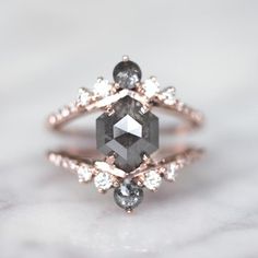 a close up of a ring on a white surface with some stones in the middle