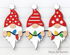 three christmas gnomes are hanging on the wall