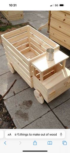 a wooden toy truck sitting on top of a cement ground next to some wood boxes