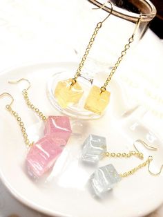 three pieces of jewelry sitting on top of a white plate next to a glass jar