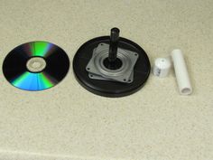 a cd sitting on top of a counter next to a white object with a green and blue disc