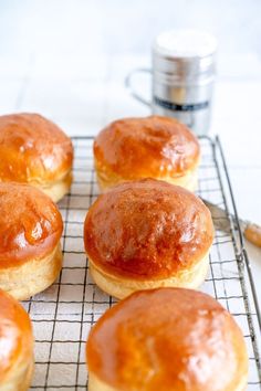 six glazed donuts sitting on a cooling rack