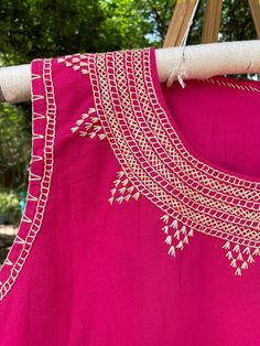 a bright pink dress hanging on a clothes line with trees in the backgroud