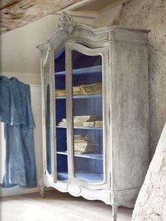 an old china cabinet with blue glass doors