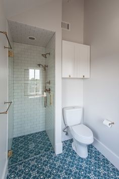 a white toilet sitting next to a walk in shower