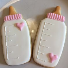 two decorated cookies in the shape of baby bottles