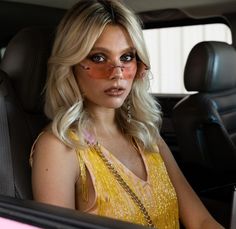 a woman sitting in the back seat of a car with her face painted like an eagle