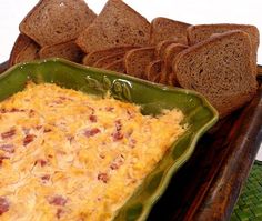 a casserole dish with bread and cheese in it on a green platter