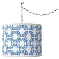 a blue and white lamp hanging from a chain on a light fixture with an intricate design