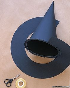 scissors and tape are on the table next to a blue cone with a hole in it