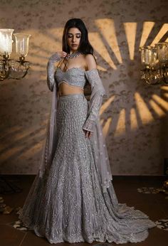 This striking silver lehenga set features all over sequin, crystal, cutdana embroidery in an A-line fit. Paired with an embroidered off shoulder blouse and matching dupatta.From Isa by Dolly Wahal's Fiori collection.DELIVERY TIMEPlease allow 8-12 weeks for your outfit to arrive.FABRIC DETAILSNetProfessional cleaning only. Silver Lehenga, Embroidered Bridal Lehenga, Cutdana Embroidery, Neeta Lulla, Engagement Ceremony, Tarun Tahiliani, Indian Fashion Designers, Pernia Pop Up Shop, Fashion Attire