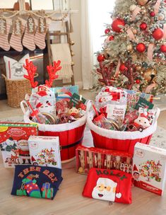 a christmas tree is decorated with red and white baskets filled with holiday gifts for children