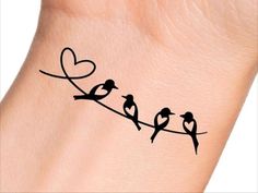 small birds sitting on a wire with heart shaped outline tattoo design for women's wrist